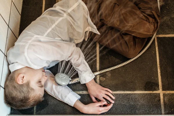 Overhead view of boy passed out in bathroom — Stock Photo, Image