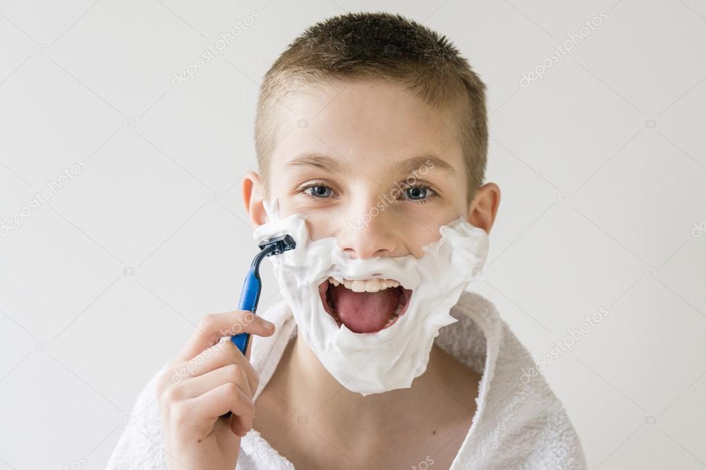 Excited Young Boy Shaving Face with Razor