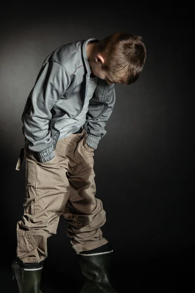 Eenzame jongen kijkt zijn oversized kleren — Stockfoto