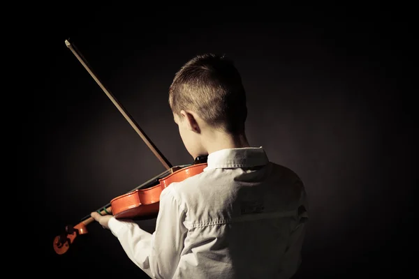 Widok z tyłu gry na skrzypcach w zaciemnionym pokoju dziecka — Zdjęcie stockowe