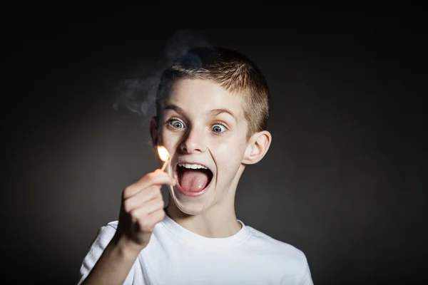 Excited male child yelling with flaming match — Stock Photo, Image