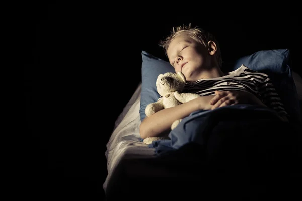 睡在床上的毛绒玩具熊的可爱男孩 — 图库照片