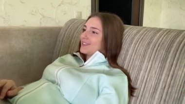 Evde dizüstü bilgisayarla çalışan mutlu genç kız.