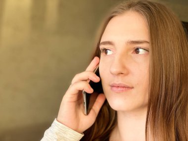 Çekici genç bayan konuşan cep telefonu ev fotokopi alanı