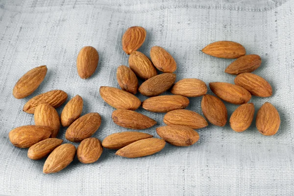 Close up portrait of Burlap sack with almonds spilling out — Stock Photo, Image