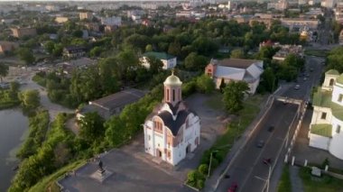 Kamera, küçük bir Avrupa şehrindeki nehir kıyısındaki küçük bir kilisenin etrafında dönüyor.