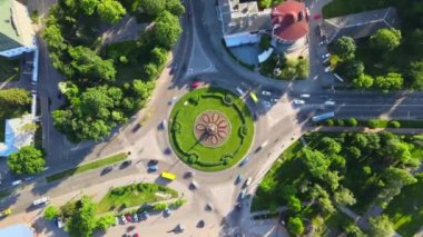 Güneşli bir günde küçük Avrupa şehrinde yuvarlak arabalı yuvarlak kavşaklı yolun 4k hava manzaralı zaman çizelgesi
