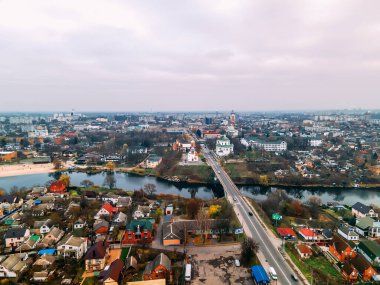 Ukrayna 'nın Kyiv bölgesinde, bulutlu bir sonbahar gününde, Avrupa' nın küçük bir kentindeki nehir ve köprü yakınlarındaki iki eski kilisenin hava manzarası