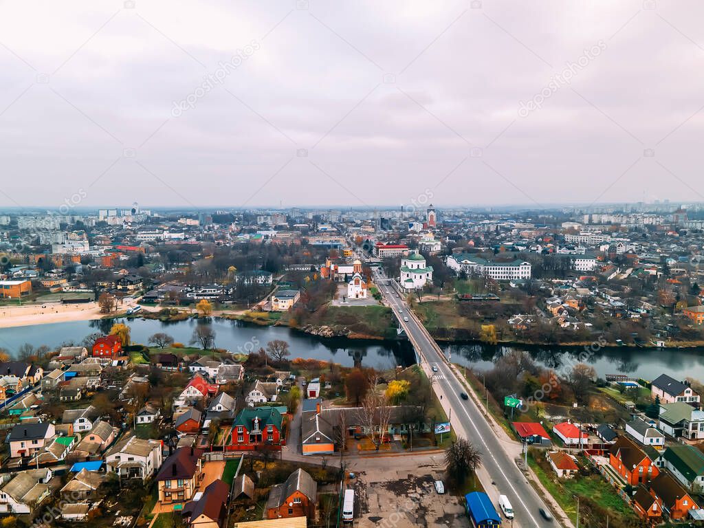 Aerial view of two old churches near river and bridge in small european city at cloudy autumn day, Kyiv region, Ukraine