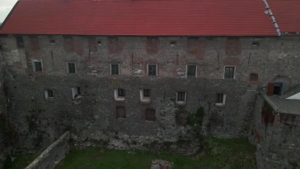 Drone vuela sobre el castillo medieval en la montaña en la pequeña ciudad europea en el día nublado de otoño — Vídeos de Stock