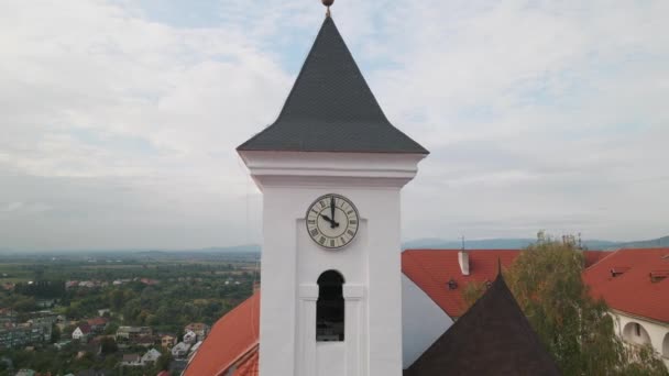 Drone vuela sobre la torre del reloj en el castillo medieval en la montaña en la pequeña ciudad europea en el día nublado otoño — Vídeos de Stock