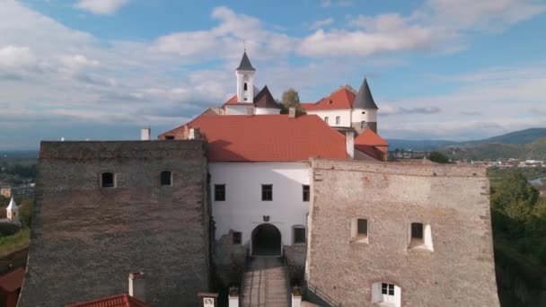 Вид с воздуха на средневековый замок на горе в маленьком европейском городе в облачный осенний день — стоковое видео