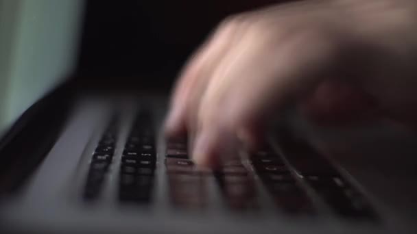 暗い部屋でキーボードのラップトップコンピュータに入力して作業している認識できないプログラマーの極端なクローズアップ手,映像を高速化 — ストック動画