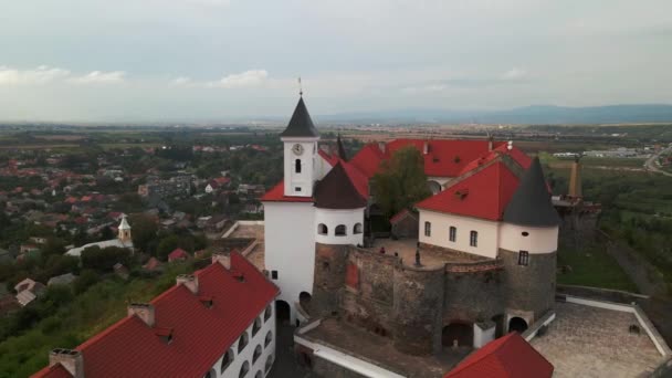Дрони літають над середньовічним замком на горі в маленькому европічному місті в похмурий осінній день. — стокове відео
