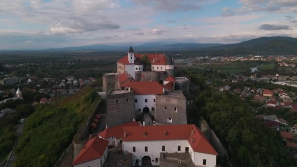 Drone vuela sobre el castillo medieval en la montaña en la pequeña ciudad europea en el día nublado de otoño — Vídeo de stock