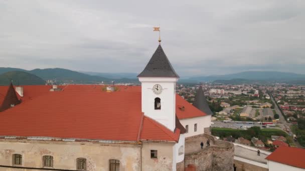 Drone vliegt over klokkentoren in middeleeuws kasteel op berg in kleine Europese stad op bewolkte herfstdag — Stockvideo