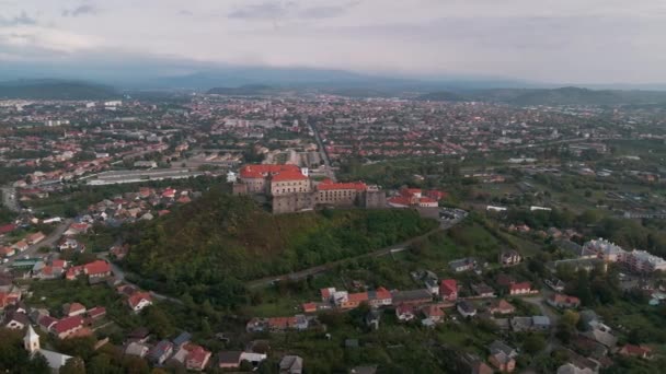 Avrupa 'nın küçük bir şehrinde, bulutlu bir sonbahar gününde dağdaki ortaçağ şatosunun havadan görünüşü — Stok video