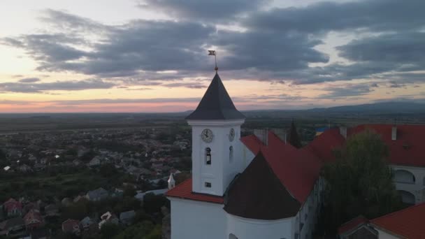 Avrupa 'nın küçük bir şehrindeki dağdaki ortaçağ şatosunun parlak sonbahar günbatımında havadan görünüşü — Stok video