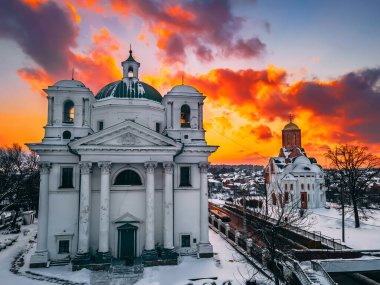 Katedral ve kilisenin karla kaplı küçük Avrupa şehrindeki parlak kış günbatımında hava manzarası