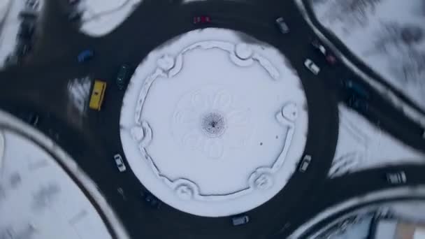 4k luchtfoto van rotonde weg met cirkelvormige auto 's in besneeuwde kleine Europese stad in de winter dag, versnellen — Stockvideo