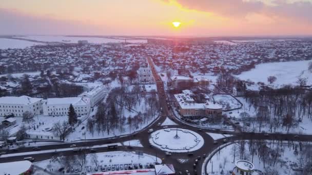 Kışın günbatımında kar üzerinde uçan insansız hava aracı küçük bir Avrupa şehrini kapladı, HDR — Stok video