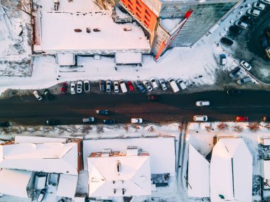 Kış bulutlu bir günde karla kaplı çatıları olan Avrupa 'nın küçük bir kentindeki yol manzarası.