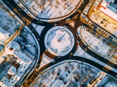 Kış güneşli bir günde, Avrupa 'nın küçük bir şehrinde yuvarlak arabalarla çevrili yol manzarası. Kyiv bölgesi, Ukrayna