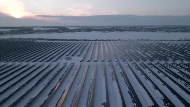 Drohnen fliegen über Solarfarm. Erneuerbare grüne Energie und Elektrotechnologie. Feld der Sonnenkollektoren steht in einer Reihe in den Feldern für die Stromerzeugung im Winter Sonnenuntergang. Grünes Energiekonzept. — Stockvideo
