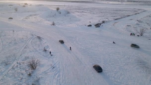 Muž lyžující s lanem za autem přes zasněženou silnici — Stock video