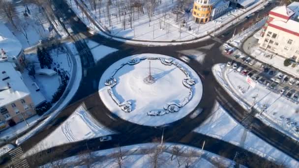 4k εναέρια άποψη της κυκλικής οδού με κυκλικά αυτοκίνητα στο χιόνι καλύπτονται μικρή ευρωπαϊκή πόλη κατά τη χειμερινή ημέρα, επιταχύνει — Αρχείο Βίντεο