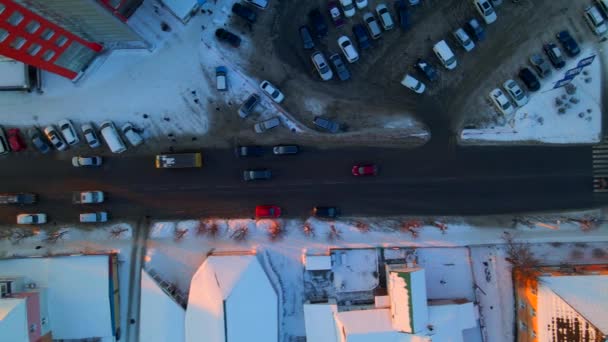 Góra w dół anteny perspektywy ulicy. Drone widok ruchu samochodowego na drodze przechodzącej przez miasto w zimowy słoneczny wieczór, — Wideo stockowe