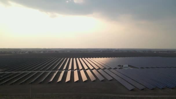 Blick aus der Luft in große Sonnenkollektoren auf einem Solarpark bei Sonnenuntergang im Frühjahr. Solarzellenanlagen. Videomaterial 4k. — Stockvideo