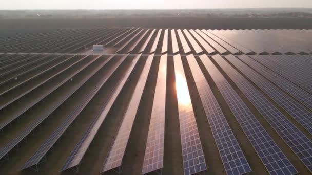 在早春的日落时分,空中无人飞机俯瞰着一个太阳能农场的大型太阳能电池板.太阳能电池发电厂。影像4k. — 图库视频影像