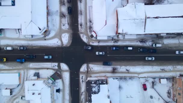 Perspectiva aérea de cima para baixo da rua. Vista do drone do tráfego do carro na estrada que passa através da cidade pequena na noite do inverno, — Vídeo de Stock