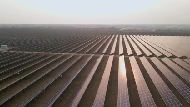 Vista aérea drone em grandes painéis solares em uma fazenda solar no início da primavera pôr do sol. Centrais de energia solar. imagens de vídeo 4k. — Vídeo de Stock