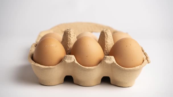 Eggs disappear from small Cardboard egg box on white background. Stop motion animation — Stock Video