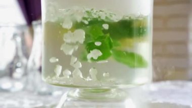 Limonlu Citrus mojito limonatasında ağır çekim baloncuklar ve soğuk, köpüklü, kuru buzlu, içecek için hazırlanmış nane şekeri.