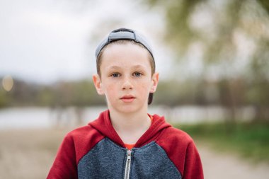 Yüzünde çiller, yüzeysel alan derinliği olan ciddi bir gencin yakın plan portresi.