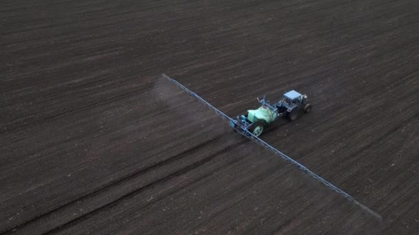 Potente tractor agrícola aplicar fertilizante mineral y nitrógeno en el suelo en el campo. Concepto de trabajo en la explotación agrícola. — Vídeos de Stock