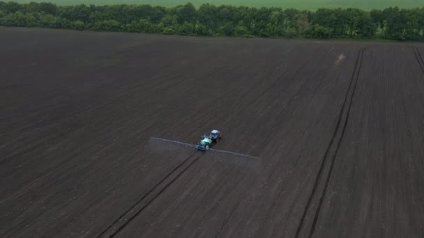 Potente tractor agrícola aplicar fertilizante mineral y nitrógeno en el suelo en el campo. Concepto de trabajo en la explotación agrícola. — Vídeo de stock