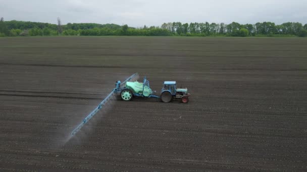 Potente tractor agrícola aplicar fertilizante mineral y nitrógeno en el suelo en el campo. Concepto de trabajo en la explotación agrícola. — Vídeos de Stock