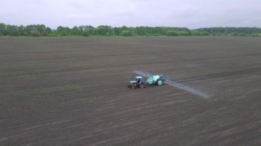 Güçlü tarım traktörü arazide mineral ve nitrojen gübresi uygular. Tarım çiftliğinde çalışma kavramı.