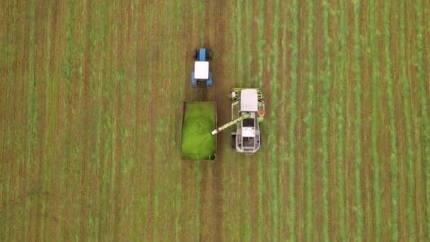 Disparo aéreo de cámara lenta de cosechadora moderna cargando cebada en remolques de tractores. Concepto de: Tractor, Cosecha, Drone b-roll metraje, Eco. — Vídeo de stock