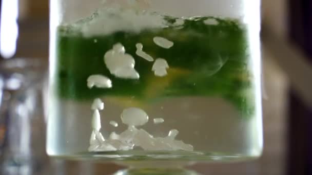 Медленное движение пузырьков в цитрусовом мохито-лимонаде с лимоном и мятой в холодной газированной воде с сухим льдом, приготовленным для питья — стоковое видео