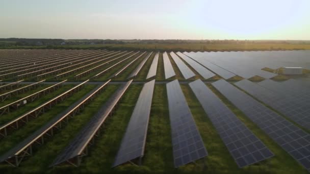 Yaz günbatımında güneş çiftliğindeki büyük güneş panellerine hava aracı görüntüsü. Güneş pili santralleri. görüntüler 4k. — Stok video