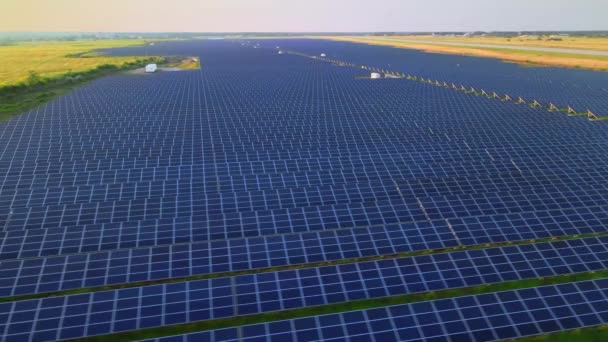 Vista aérea de drones en grandes paneles solares en una granja solar al atardecer brillante. Plantas de energía solar. Vídeo HDR 4k. — Vídeo de stock