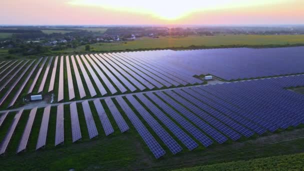 Flygdrönare vy in i stora solpaneler på en solgård vid ljus solnedgång. Solcellsanläggningar. HDR-video 4k. — Stockvideo