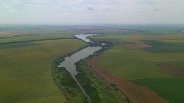İnsansız hava aracı bulutlu bir günde güzel bir yaz manzarasının üzerinde uçar. İnsansız hava aracının havadan görünüşü yazın inanılmaz bir manzaranın üzerinde uçar..