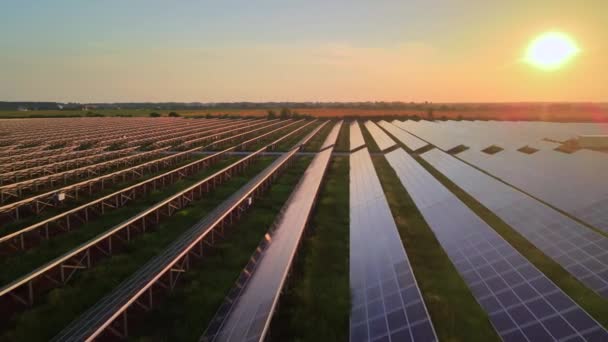 Parlak günbatımında güneş çiftliğindeki büyük güneş panellerine hava aracı görüntüsü. Güneş pili santralleri. HDR video 4k. — Stok video