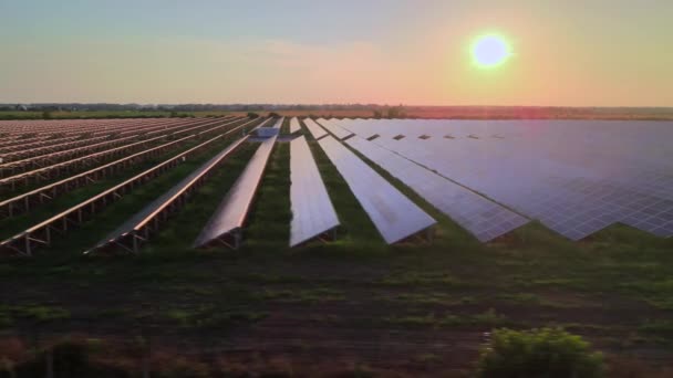 Воздушные беспилотники смотрят на большие солнечные панели на солнечной ферме на ярком закате. Солнечные батареи. Видеозапись HDR 4k. — стоковое видео
